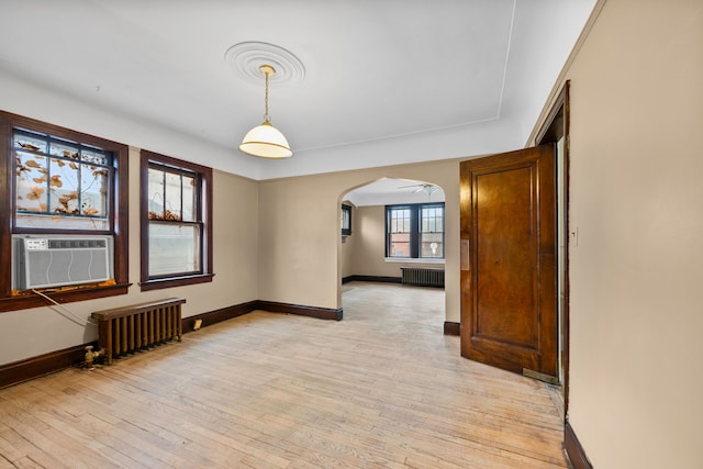 2412 Cornell St, Dearborn, MI 48124 - unfurnished room featuring radiator, light wood-style floors, and arched walkways
