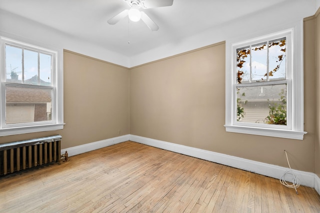 2412 Cornell St, Dearborn, MI 48124 - spare room featuring light wood finished floors, radiator heating unit, baseboards, and a wealth of natural light