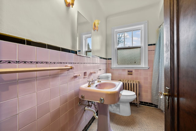 2412 Cornell St, Dearborn, MI 48124 - bathroom with toilet, a wainscoted wall, radiator heating unit, tile patterned floors, and tile walls