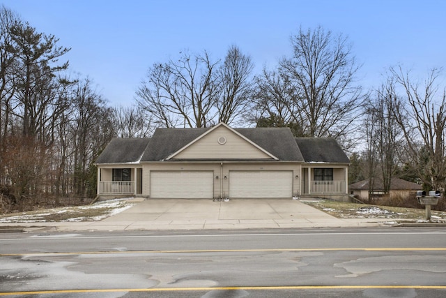 view of front facade featuring a garage, concrete driveway, and covered porch