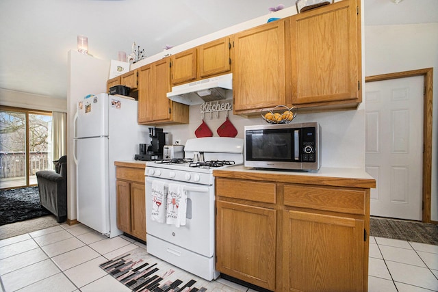 kitchen featuring light tile patterned floors, light countertops, white appliances, and under cabinet range hood