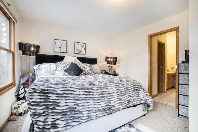 tiled bedroom with ensuite bathroom and carpet flooring