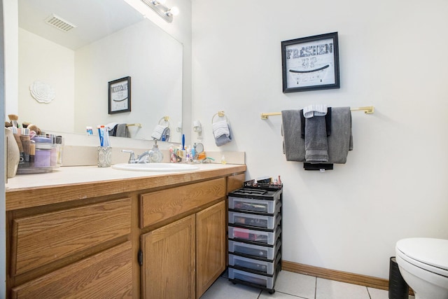 bathroom featuring visible vents, toilet, vanity, tile patterned flooring, and baseboards