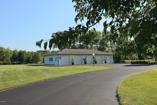 ranch-style home featuring a front lawn and community garages