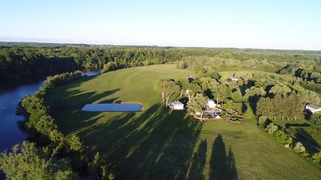 birds eye view of property with a water view and a wooded view