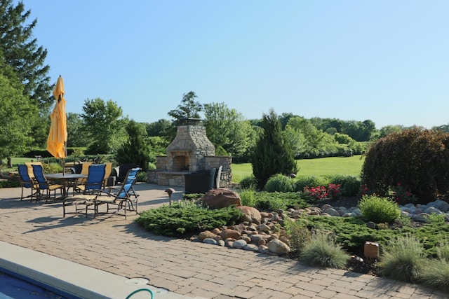 view of patio featuring an outdoor stone fireplace