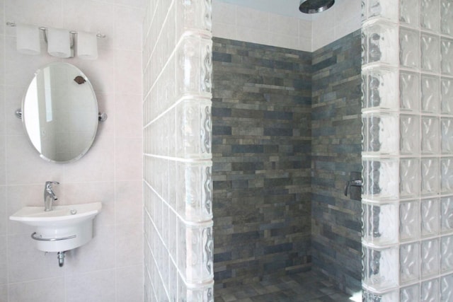 full bath featuring a sink, tile walls, and a walk in shower