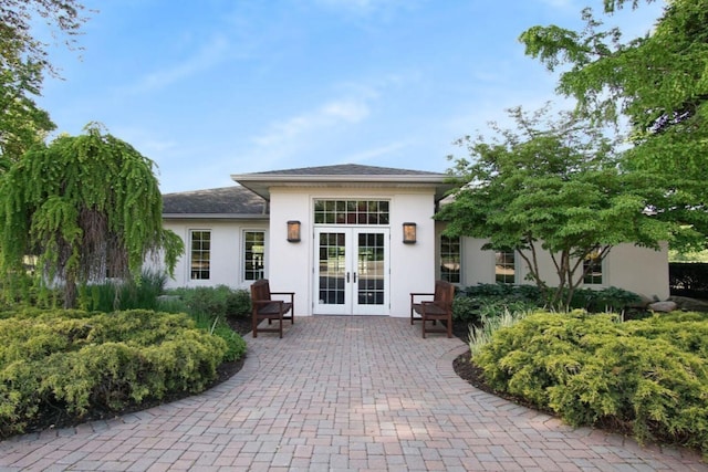 doorway to property featuring french doors and stucco siding