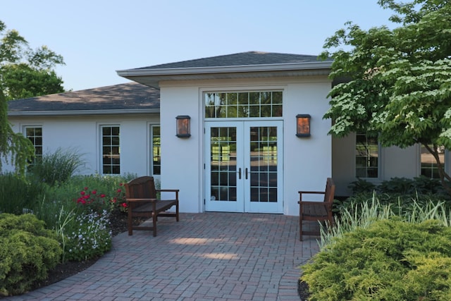 view of exterior entry featuring french doors, a patio area, and stucco siding