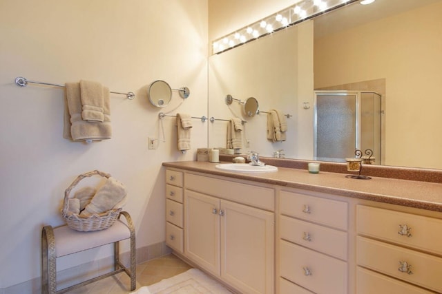 bathroom with a stall shower, tile patterned flooring, and vanity