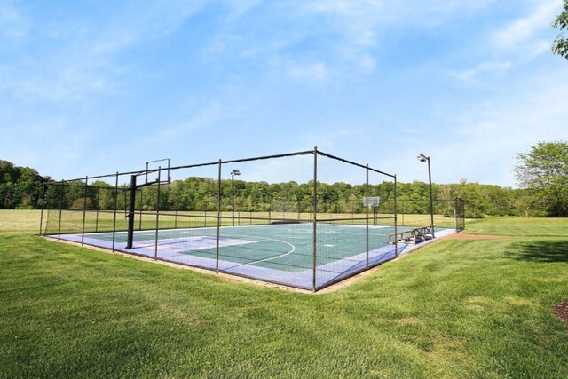 view of basketball court with a yard, fence, and community basketball court