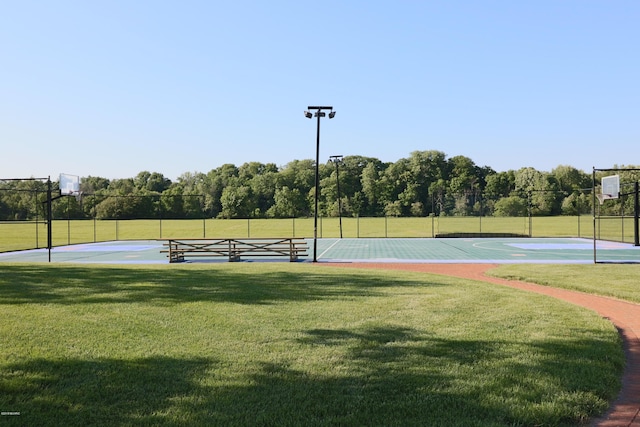 view of tennis court with community basketball court, a yard, and fence