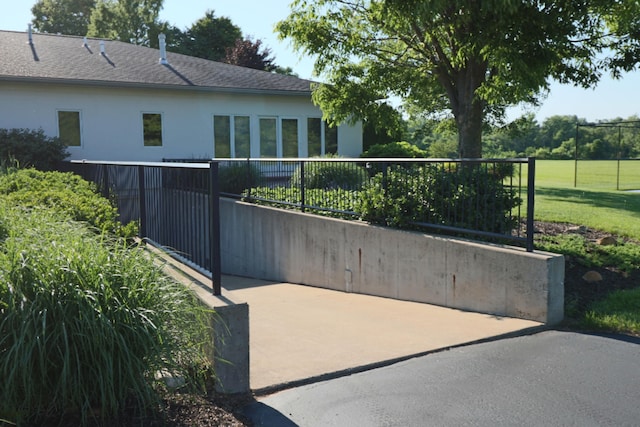 view of gate featuring fence and a lawn