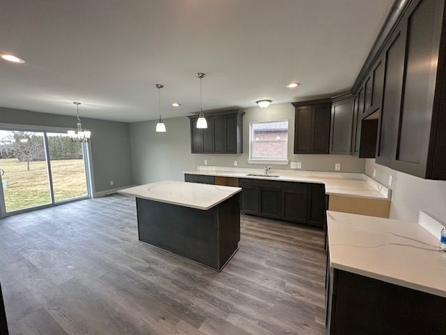 kitchen featuring recessed lighting, wood finished floors, a sink, and a center island