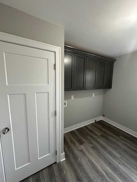 clothes washing area featuring laundry area, baseboards, and dark wood finished floors