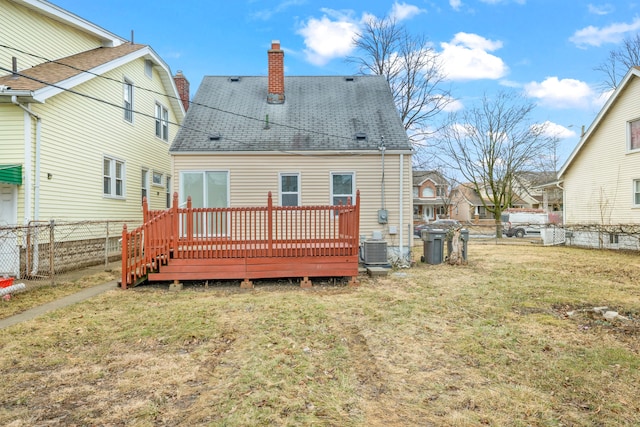 back of property featuring central air condition unit, fence, roof with shingles, a lawn, and a chimney