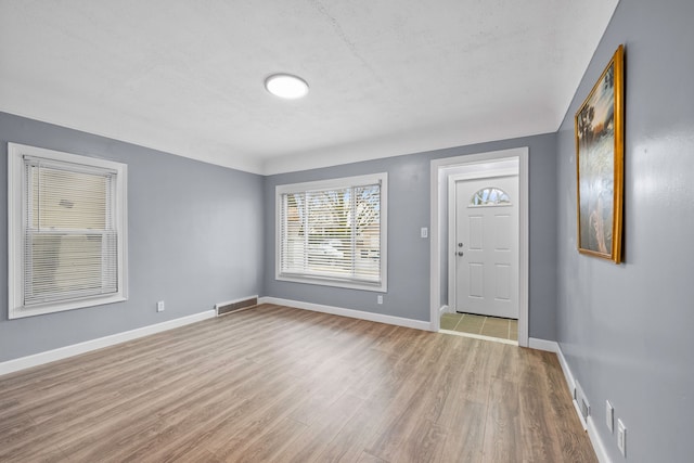 foyer featuring baseboards and wood finished floors