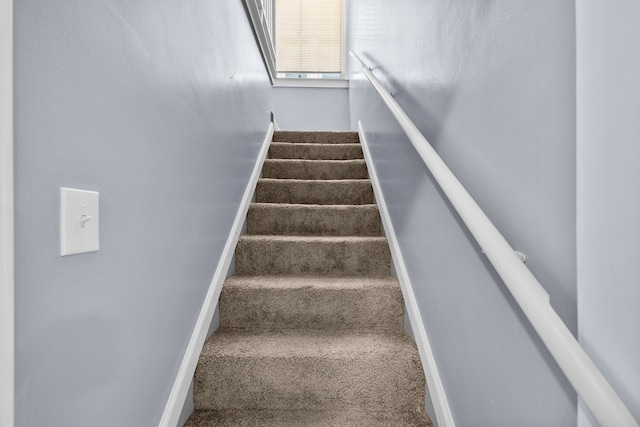 stairway featuring carpet and baseboards