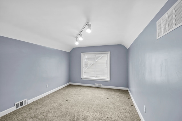 empty room featuring lofted ceiling, baseboards, and visible vents