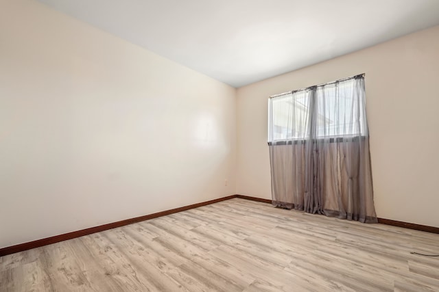 empty room with light wood-type flooring and baseboards