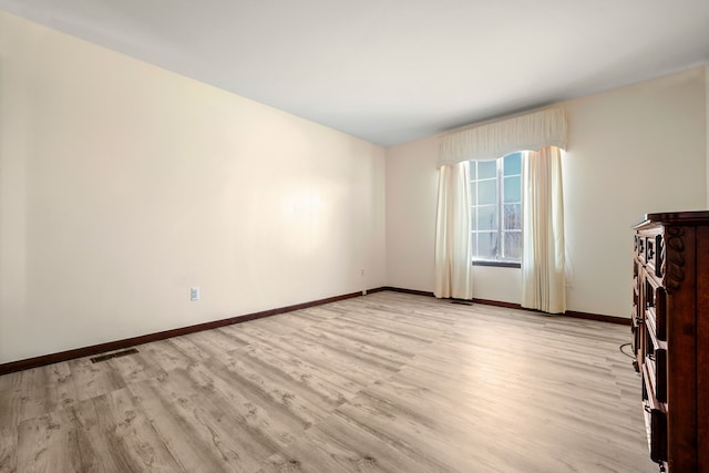 unfurnished living room with baseboards, visible vents, and light wood-style floors