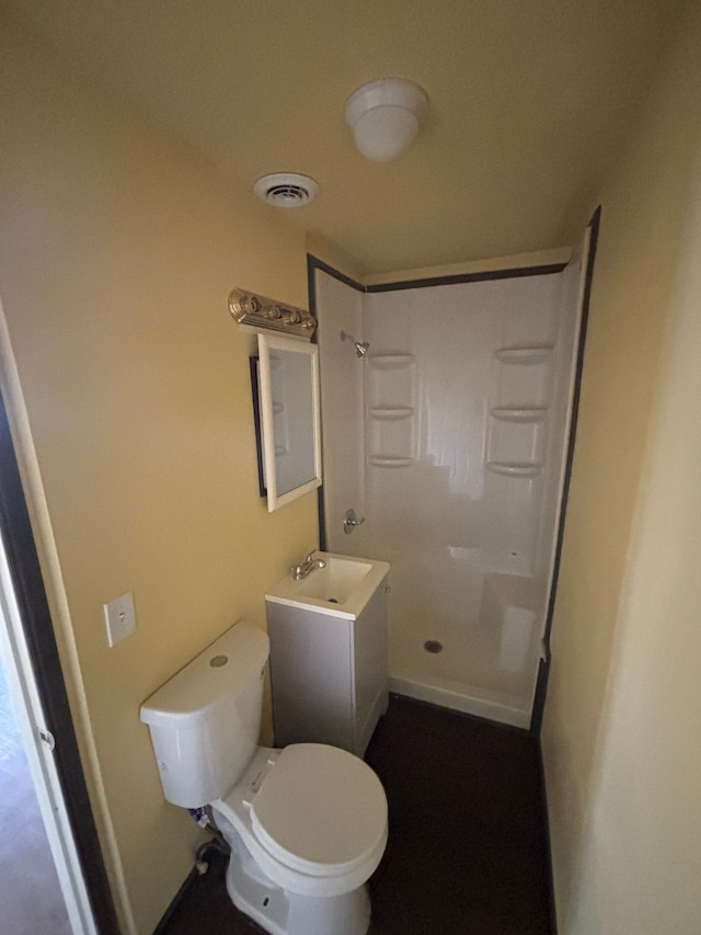 bathroom featuring a shower, visible vents, vanity, and toilet