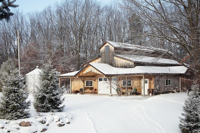 view of front of property with an attached garage and a barn