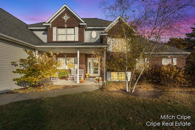 traditional-style house with a porch and brick siding