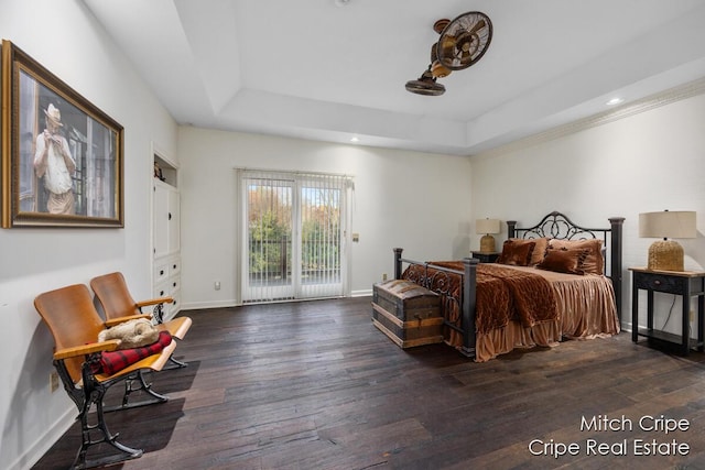 bedroom with access to outside, hardwood / wood-style floors, a raised ceiling, and baseboards