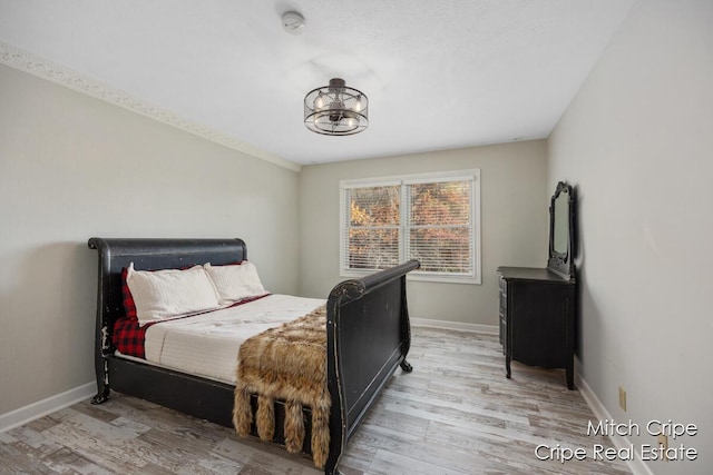 bedroom with baseboards and wood finished floors