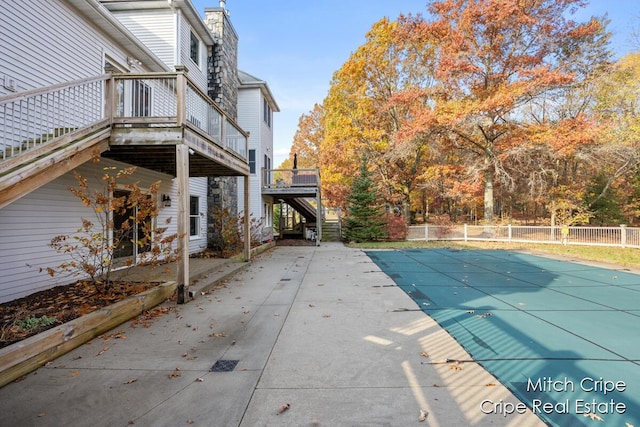 view of swimming pool with a wooden deck, stairway, fence, and a fenced in pool