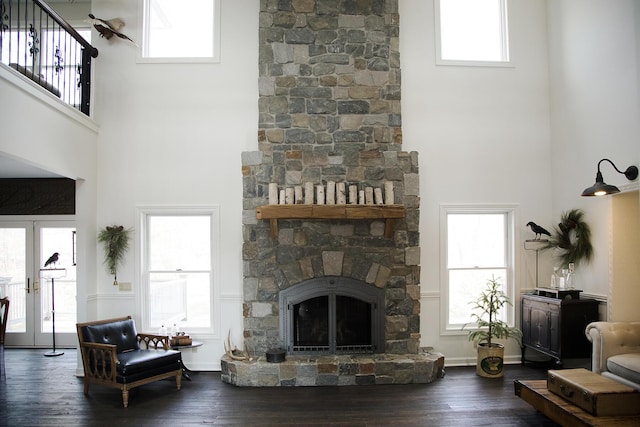 living area with french doors, a fireplace, wood finished floors, and a wealth of natural light