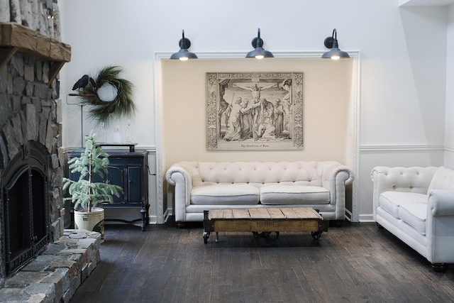 living area with a fireplace, baseboards, and hardwood / wood-style floors