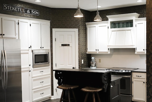 kitchen with stainless steel appliances, white cabinets, custom range hood, and wallpapered walls