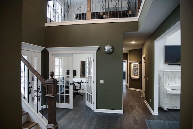 entryway featuring a high ceiling, wood finished floors, baseboards, stairs, and french doors