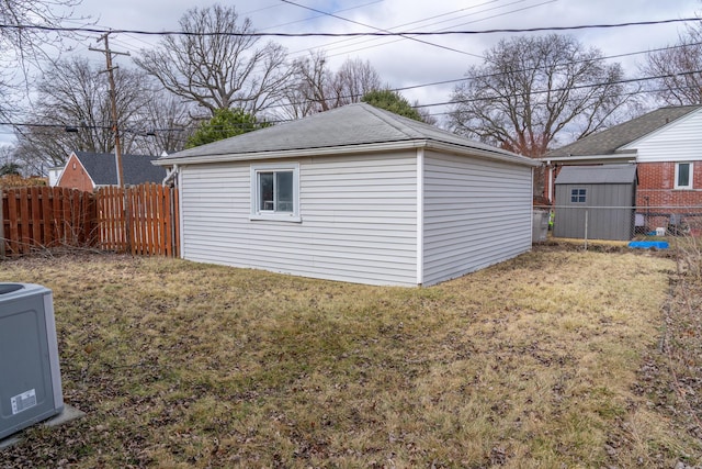 view of outbuilding with central air condition unit, fence, and an outdoor structure