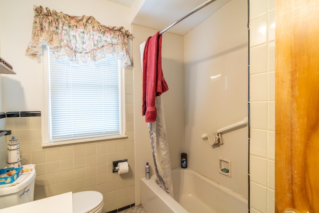 bathroom featuring shower / bath combo, tile walls, and toilet