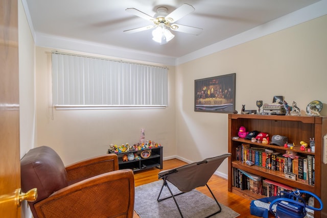 living area featuring ceiling fan, baseboards, and wood finished floors