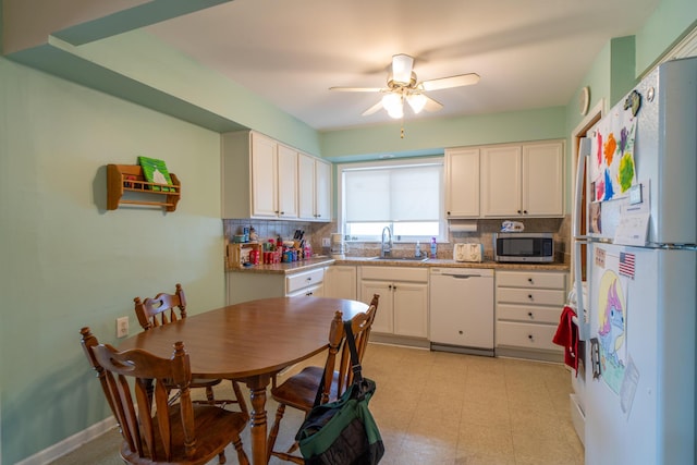 kitchen featuring white appliances, backsplash, light floors, and a sink