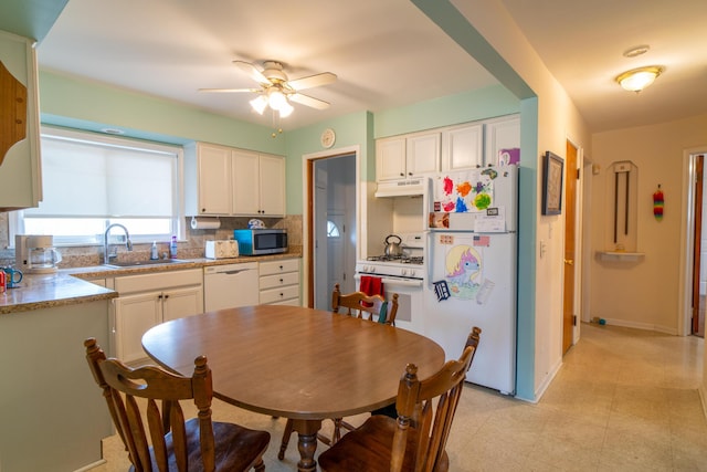 kitchen featuring white appliances, white cabinets, a sink, and under cabinet range hood