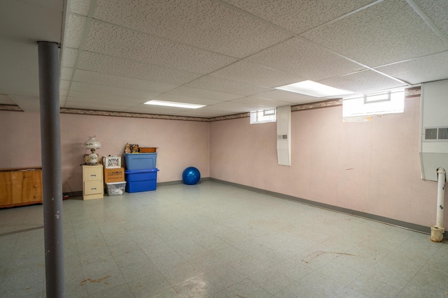 below grade area with a paneled ceiling, a healthy amount of sunlight, visible vents, and tile patterned floors