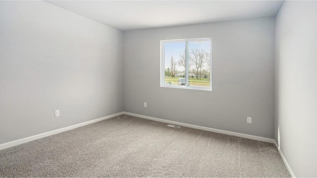 carpeted empty room with visible vents and baseboards