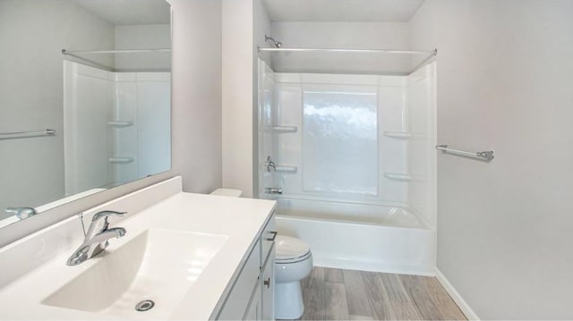 full bathroom with shower / bathtub combination, toilet, wood finished floors, vanity, and baseboards