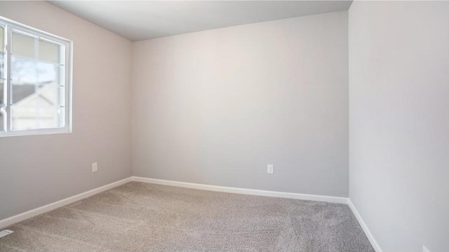 empty room featuring carpet floors and baseboards