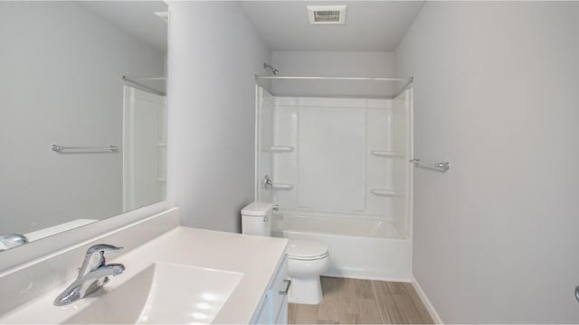 bathroom with visible vents, toilet, wood finished floors, vanity, and shower / bathing tub combination