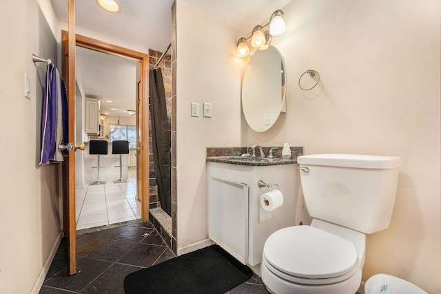 bathroom with baseboards, toilet, vanity, and a shower with shower curtain