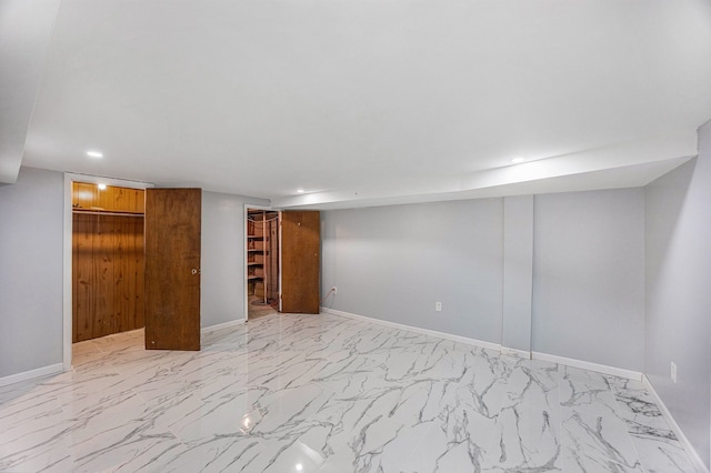 finished basement with recessed lighting, marble finish floor, and baseboards