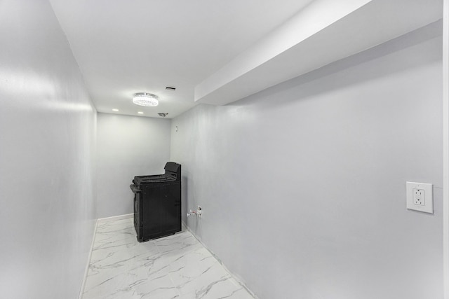 below grade area featuring marble finish floor and baseboards