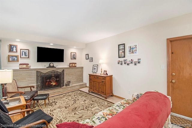 living area featuring a warm lit fireplace and baseboards