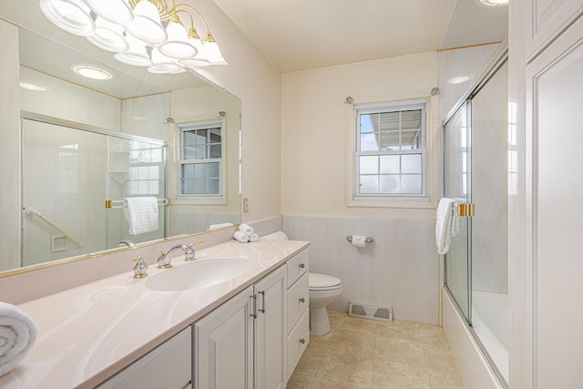 bathroom with visible vents, toilet, wainscoting, vanity, and tile patterned flooring